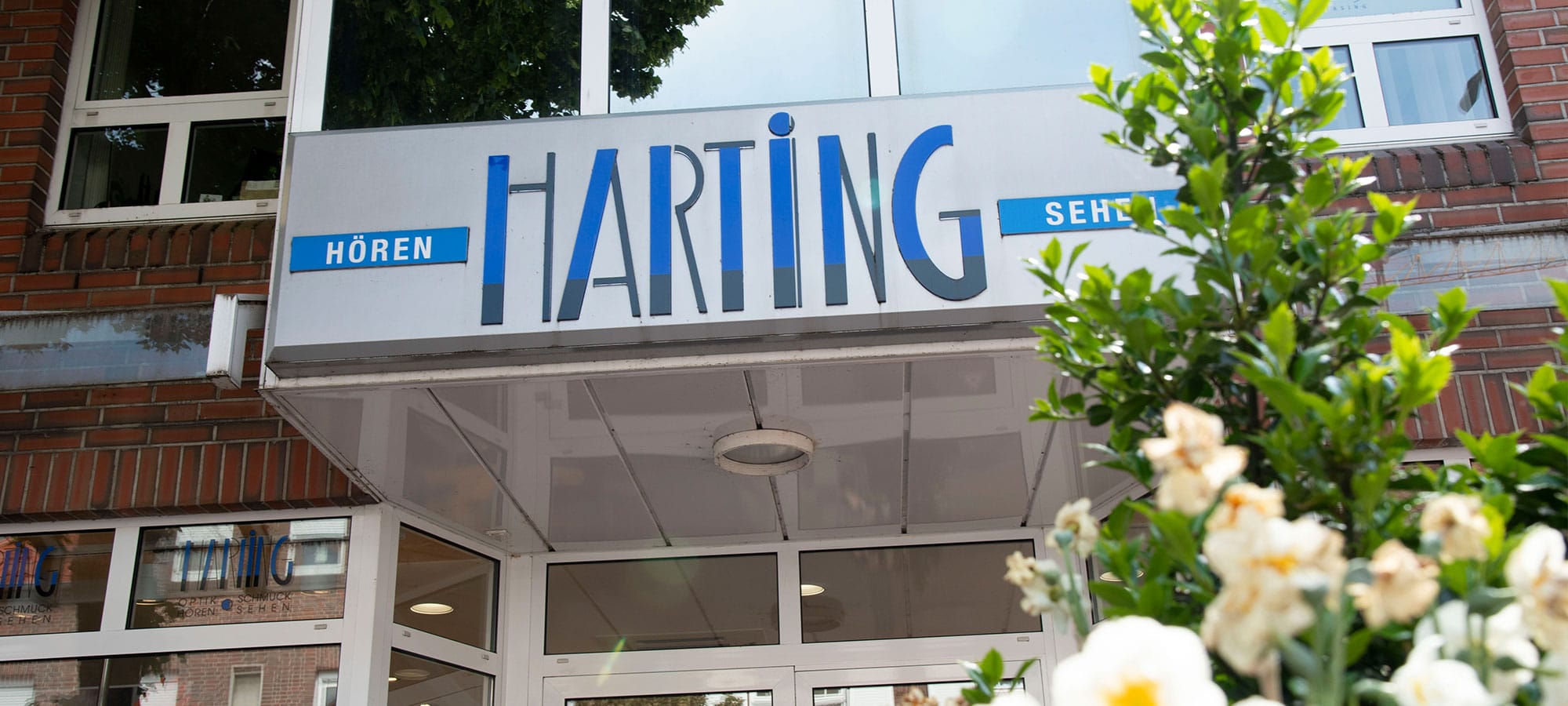Gebäude von Harting – Außenansicht. Blick nach Oben gerichtet und zeigt den Überstand, wo das Harting Logo angebracht ist.