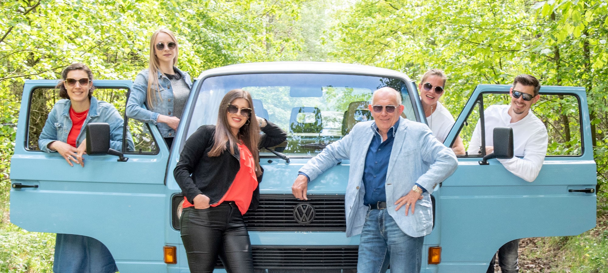 Gruppenfoto vom Harting Team mit einem blauen Van