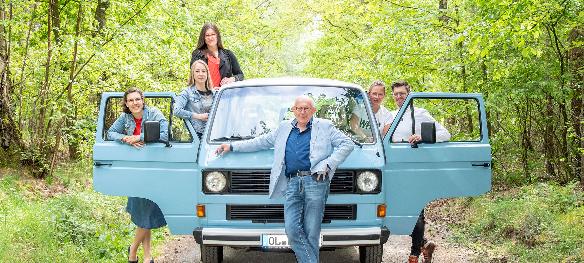 Gruppenfoto vom Harting Team mit einem blauen Van