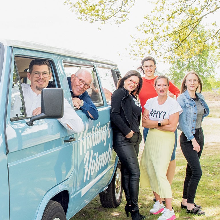 Gruppenfoto vom Harting Team mit einem blauen Van