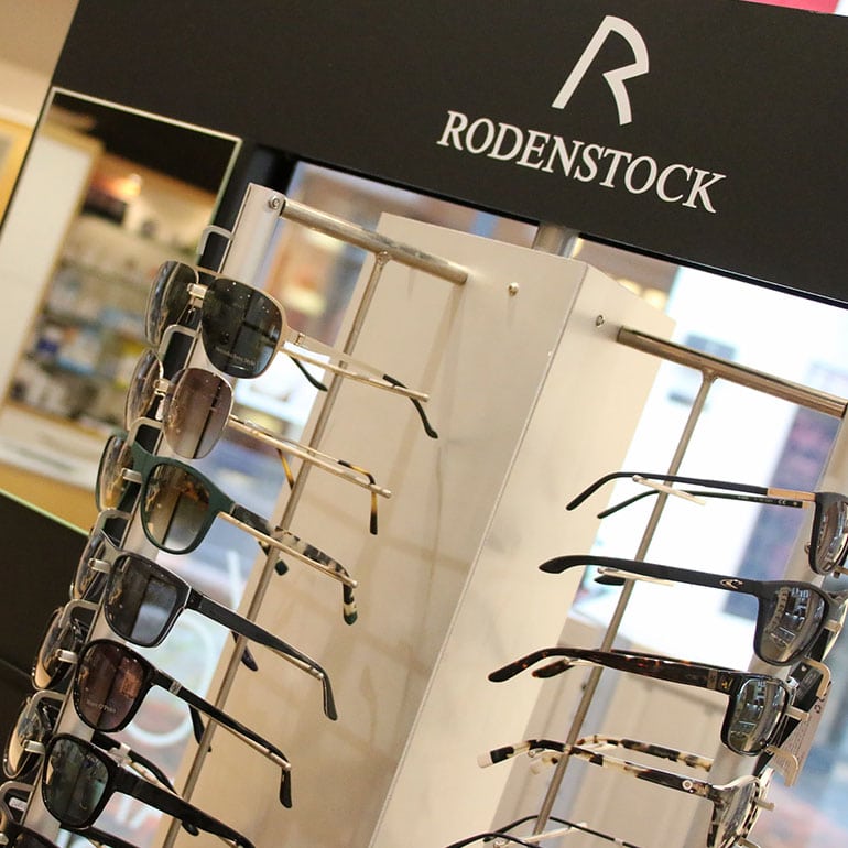Nahaufnahme eines Brillenständers von Rodenstock – bestückt mit vielen Brillen und stehend in einem Geschäft