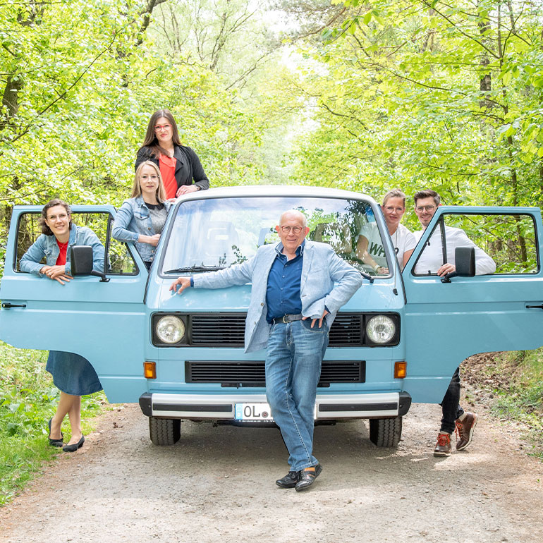 Gruppenfoto vom Harting Team mit einem blauen Van